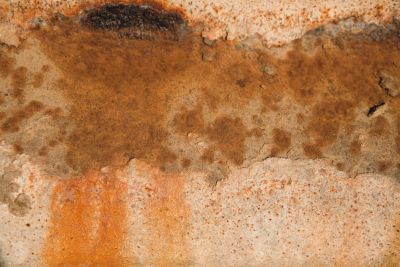 Abstract close-up of weathered, rust-streaked metal.